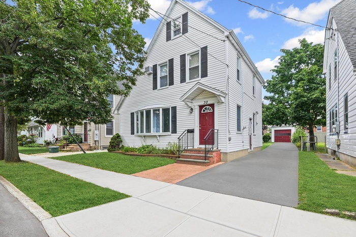 View of front of home featuring an outdoor structure and a front yard