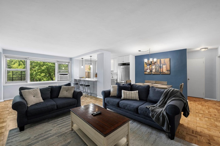 Living area featuring baseboards, a chandelier, and cooling unit