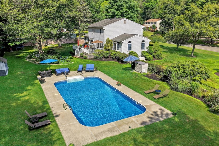 Outdoor pool with a patio area and a yard