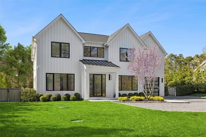 Modern inspired farmhouse featuring fence, a front lawn, a standing seam roof, and board and batten siding