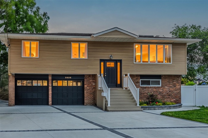 Bi-level home featuring brick siding, concrete driveway, and an attached garage