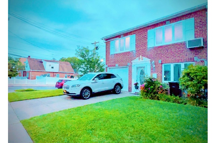 View of front of property with brick siding, concrete driveway, a garage, and a front yard