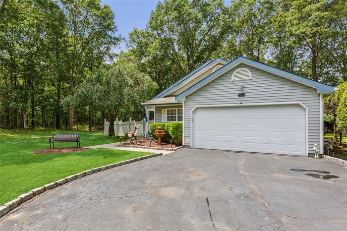 View of front of home with asphalt driveway and a front lawn