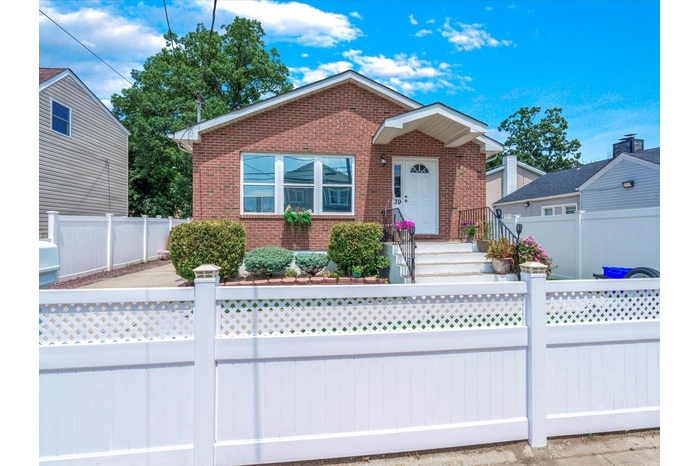 View of front facade with brick siding and a fenced front yard