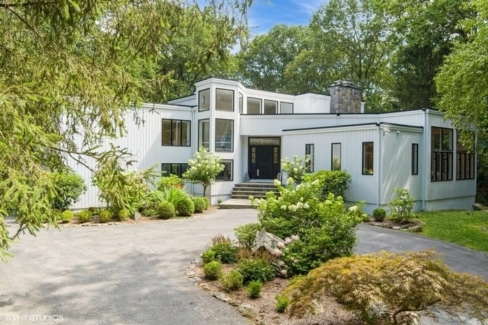 Contemporary home featuring driveway and a chimney
