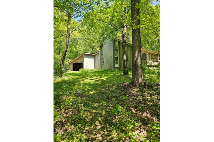 View of home and yard featuring a detached garage