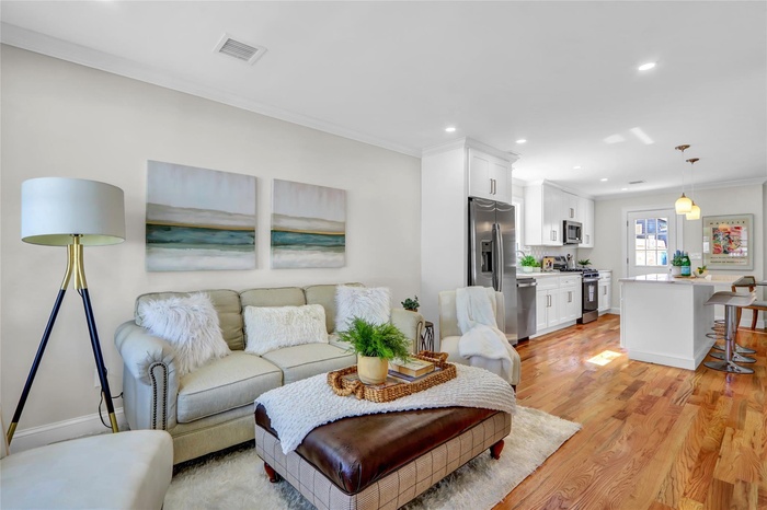 Living room featuring ornamental molding, recessed lighting, and light wood-type flooring