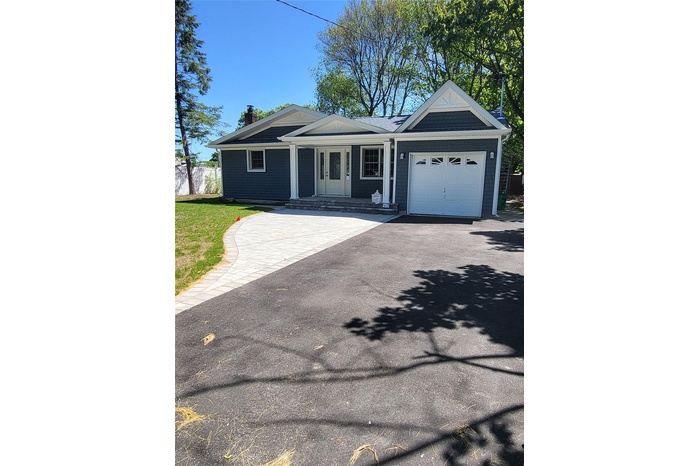 Single story home featuring a garage, asphalt driveway, and a chimney