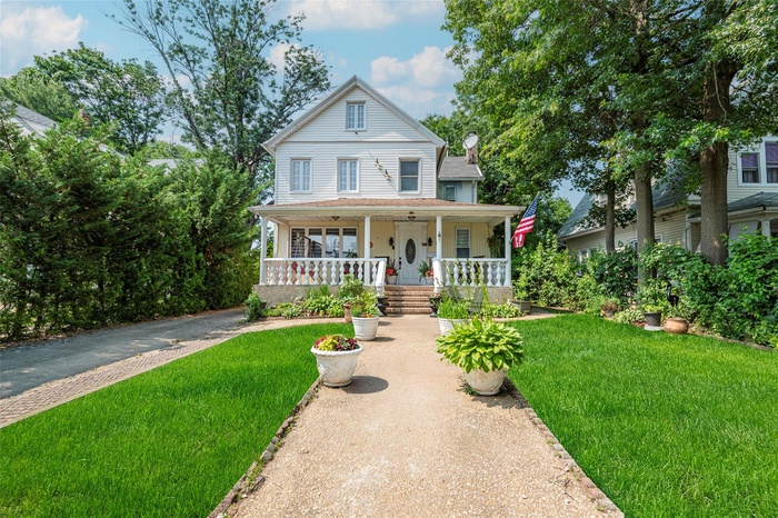 View of front of property with a porch and a front yard