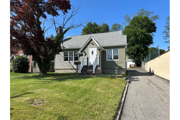 View of front of house featuring a chimney and roof with shingles