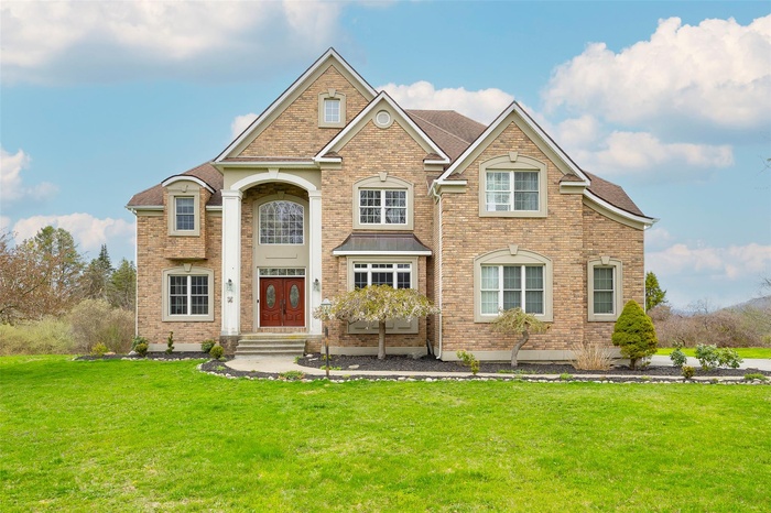View of front of house with brick siding, roof with shingles, and a front yard
