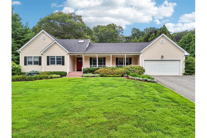 Ranch-style house featuring driveway, covered porch, a garage, a shingled roof, and a front lawn