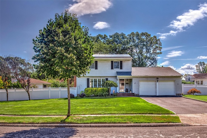 View of front facade featuring driveway and an attached garage
