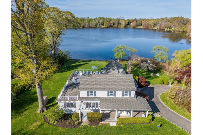 Aerial view of property and surrounding area with a nearby body of water