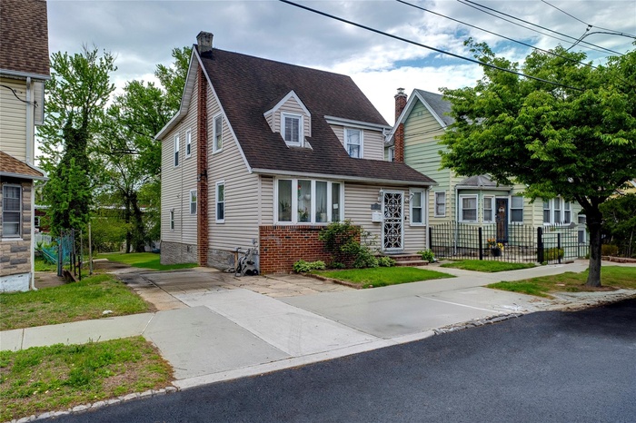 View of front of house with a chimney and a shingled roof