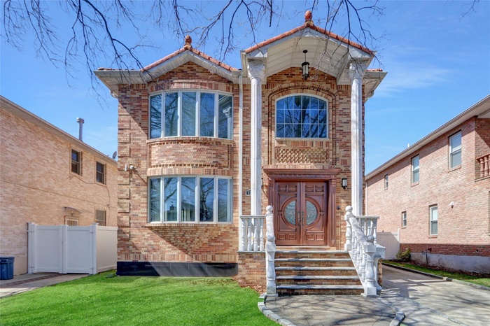 View of front of house with brick siding, fence, and a front yard