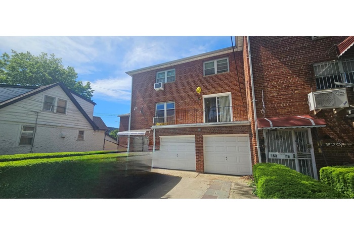View of front facade featuring brick siding, a garage, and driveway