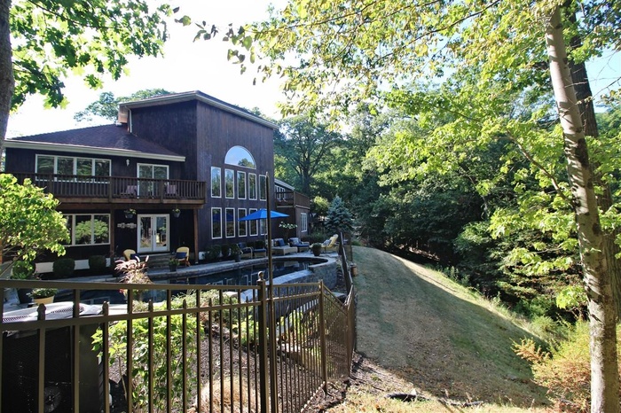 Back of property featuring french doors, a deck, and an outdoor pool
