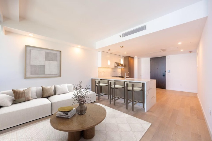 Living area with visible vents, light wood-style flooring, and recessed lighting
