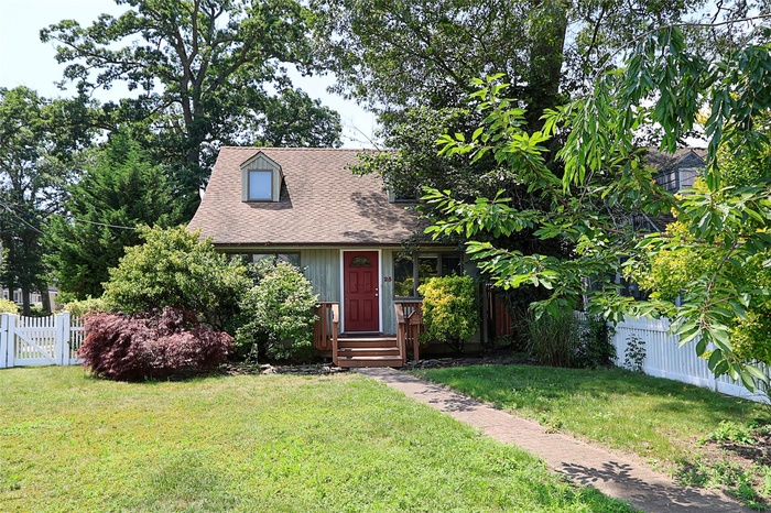 View of front of home featuring a gate and a shingled roof