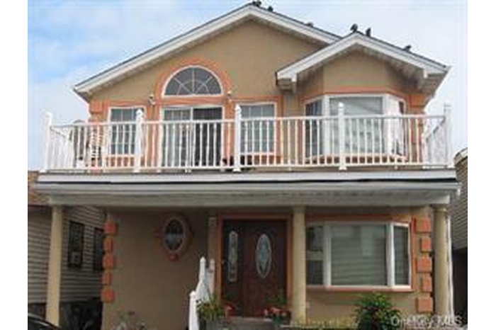 View of front of house featuring a balcony and stucco siding