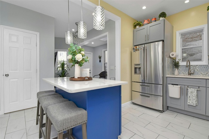 Kitchen with stainless appliances,  light marble finish floors, a center island, and recessed lighting