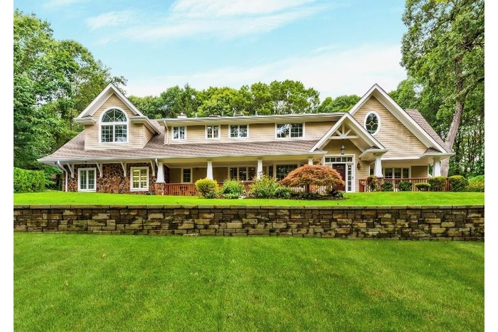 Craftsman-style house with a front lawn and covered porch