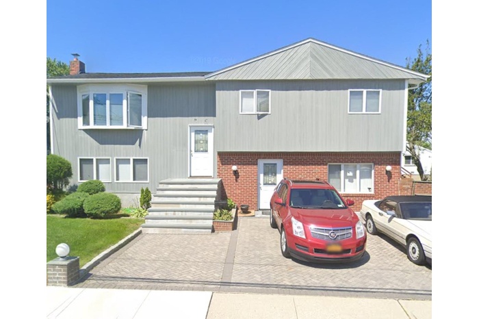 View of front of house with a chimney and brick siding
