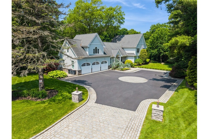 Hampton Style home featuring expansive 12 car driveway, with decorative use of cobblestones