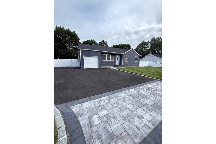 Ranch-style house with a garage and asphalt driveway