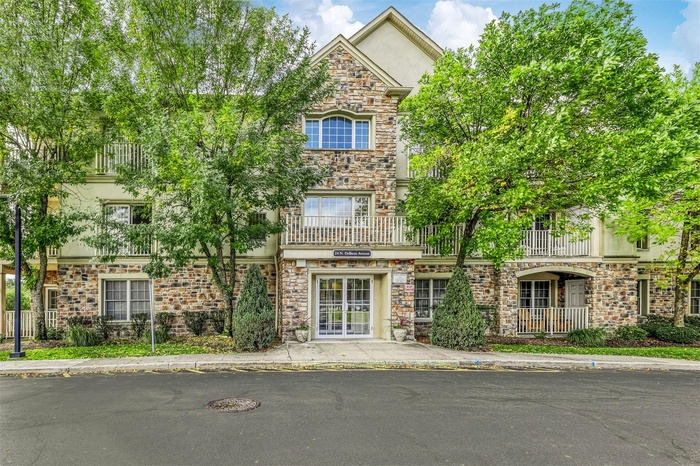 View of front facade featuring stucco siding and stone siding