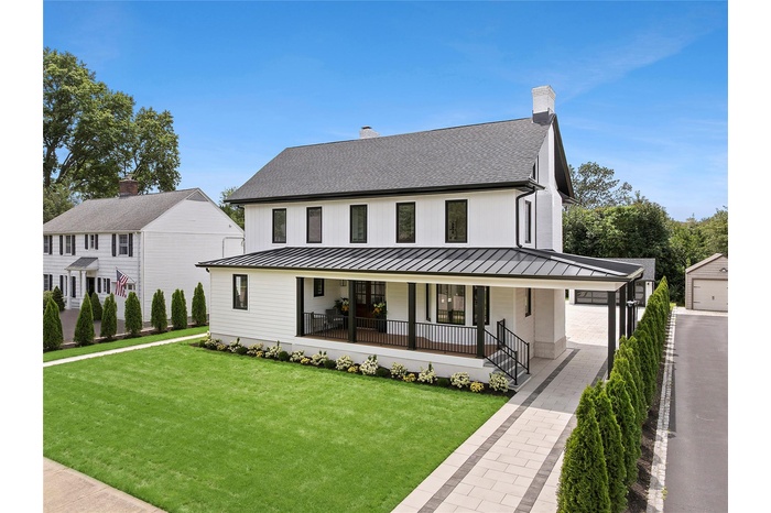 Stunning new construction home with a chimney, a front porch, carport, and 2 car garage