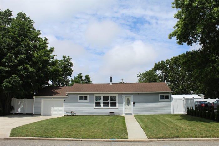 Ranch-style home featuring a garage and concrete driveway