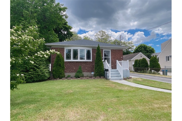 View of front of house with brick siding and a front lawn