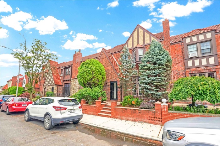 View of front of home featuring a chimney, a residential view, and stucco siding