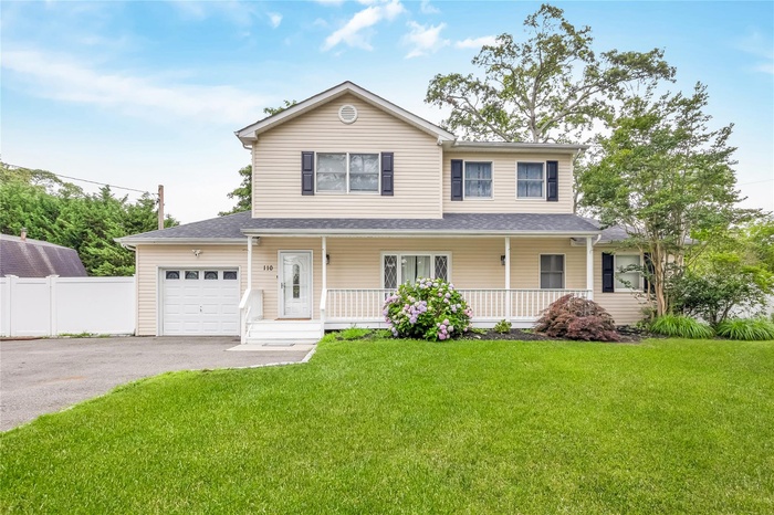View of front of property with asphalt driveway, an attached garage, and covered porch