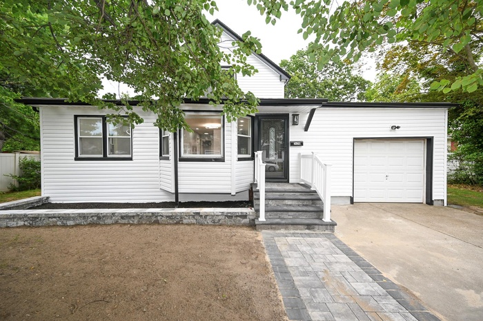 View of front facade featuring concrete driveway and an attached garage