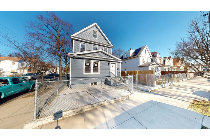 American foursquare style home featuring a residential view, a fenced front yard, and a gate