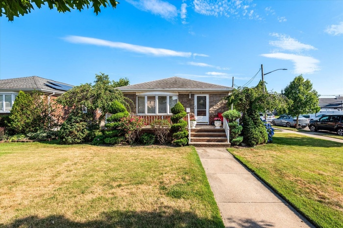 Bungalow-style house featuring a front yard and brick siding