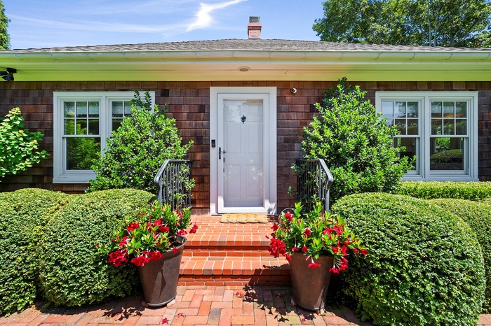 Entrance to property featuring a chimney and a shingled roof