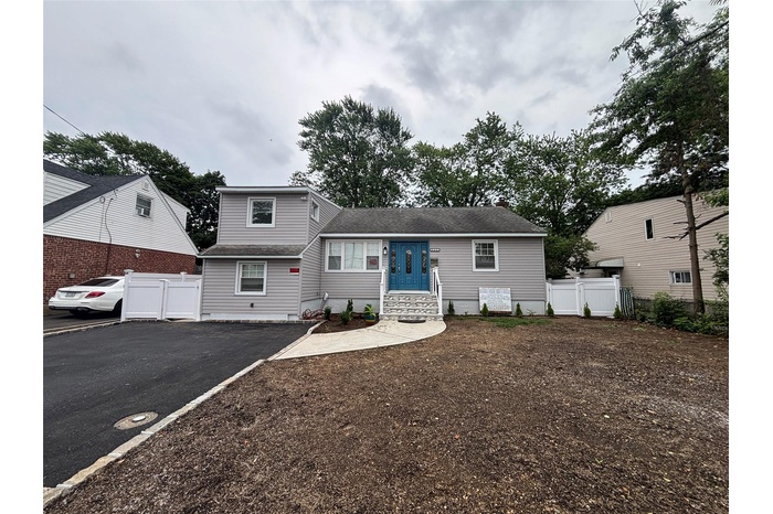 Tri-level home featuring driveway and a shingled roof