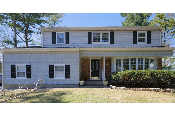 View of front of house featuring brick siding and a front yard