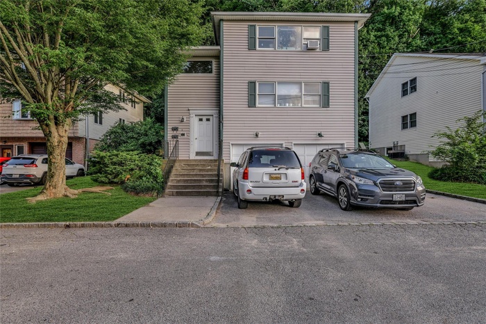 View of front of property featuring asphalt driveway and a garage
