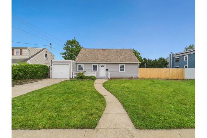 View of front of home featuring driveway, a garage, and a shingled roof