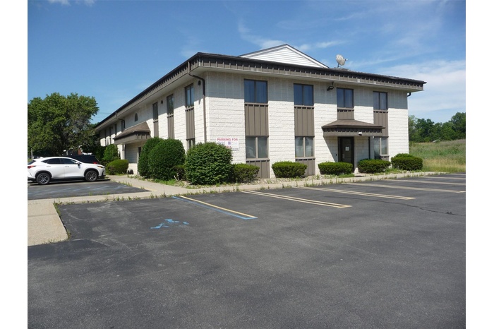 View of property featuring uncovered parking