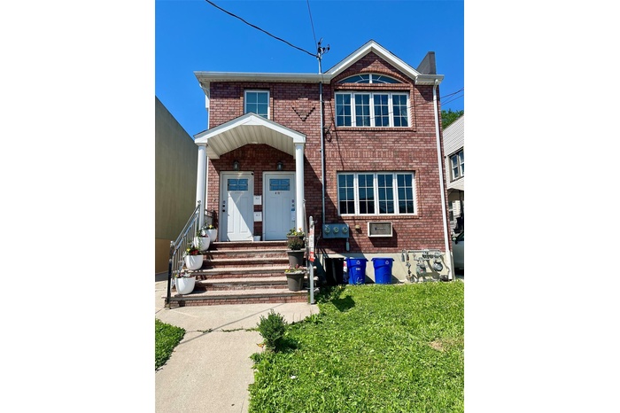 View of front of house with brick siding and a front yard