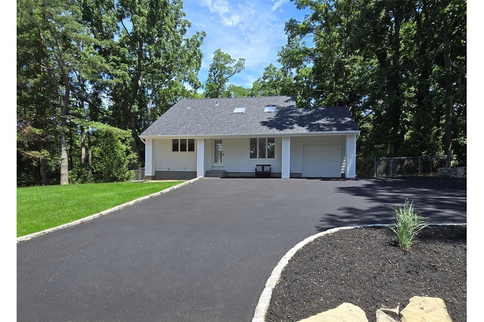 View of front of house featuring an attached garage, a porch, and asphalt driveway