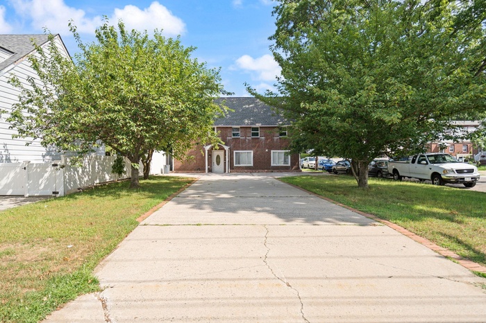 View of front of home featuring driveway and brick siding