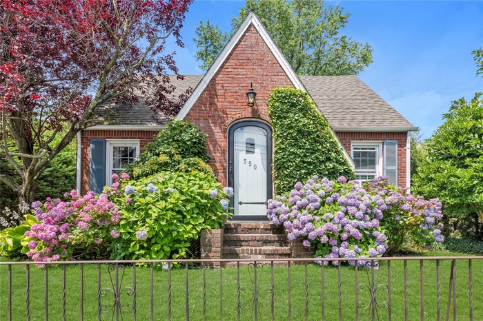 Tudor house with a shingled roof, brick siding, and entry steps