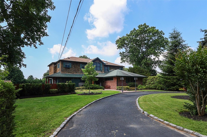 View of front facade with a front yard and driveway